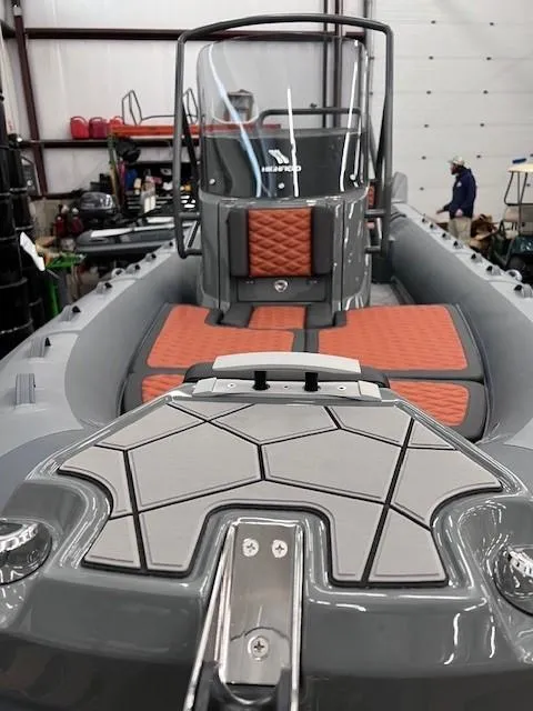 Slide: The Image of 2024 Highfield Sport 660 boat with sleek design and orange seating in a workshop. - 9