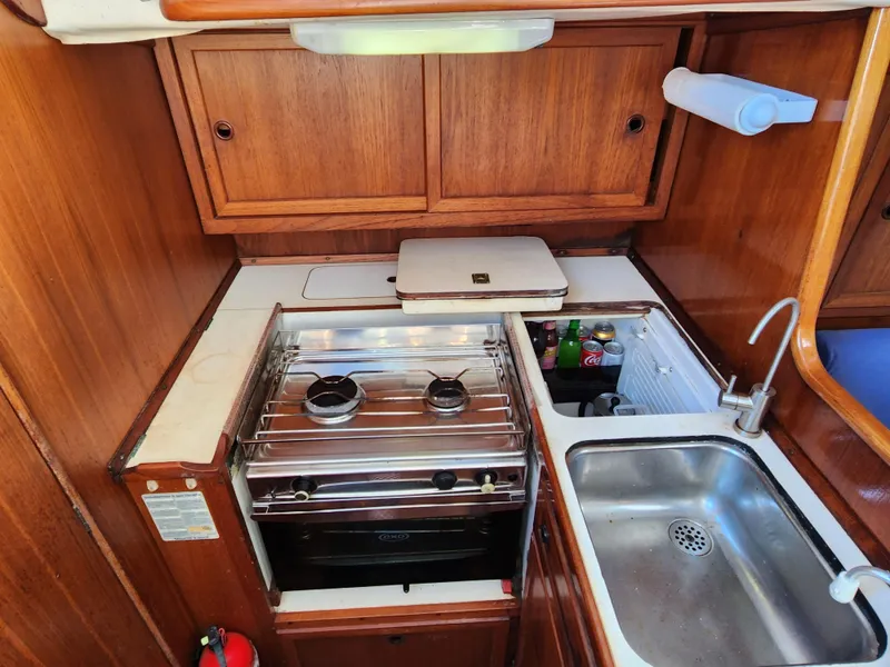 Slide: The Image of 1989 Granada 375 Atlantica yacht kitchen with stove, sink, and wooden cabinets. - 13