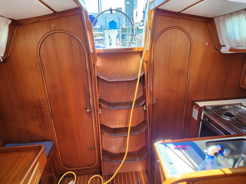Slide: The Image of Interior of 1989 Granada 375 Atlantica sailboat with wooden cabinetry and compact kitchen. - 14