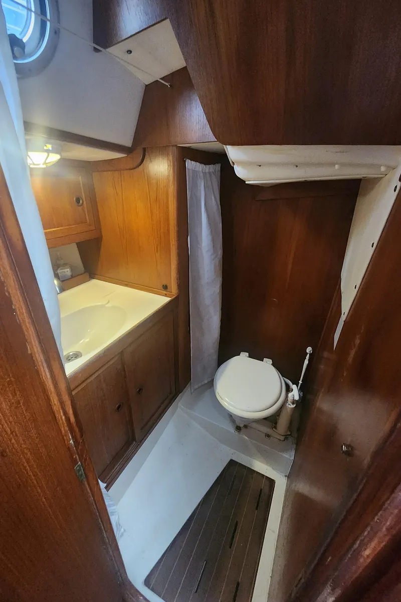 Slide: The Image of 1989 Granada 375 Atlantica boat bathroom with wooden cabinetry and compact toilet. - 21