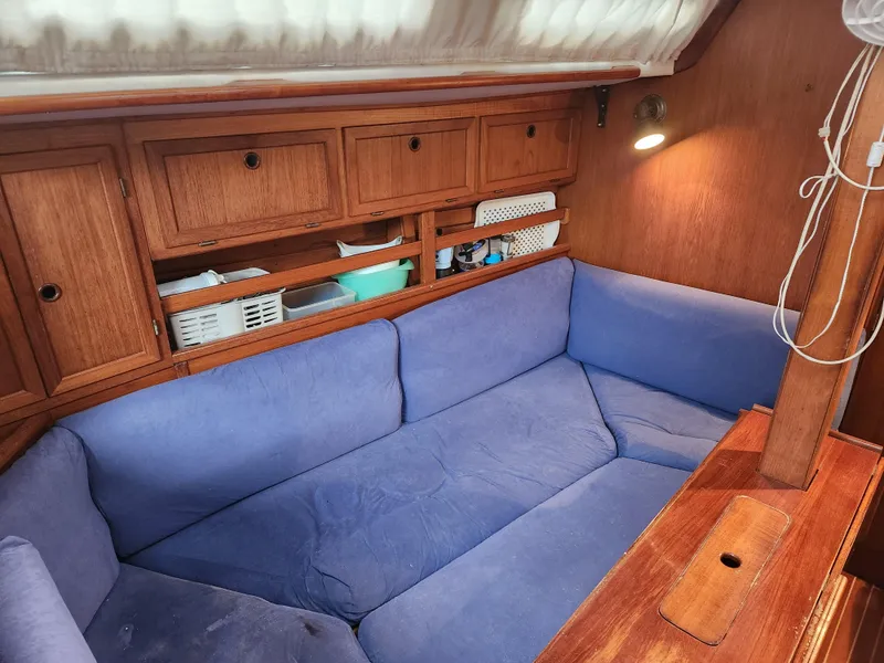 Slide: The Image of Interior of 1989 Granada 375 Atlantica sailboat with blue cushioned seating and wooden cabinets. - 7