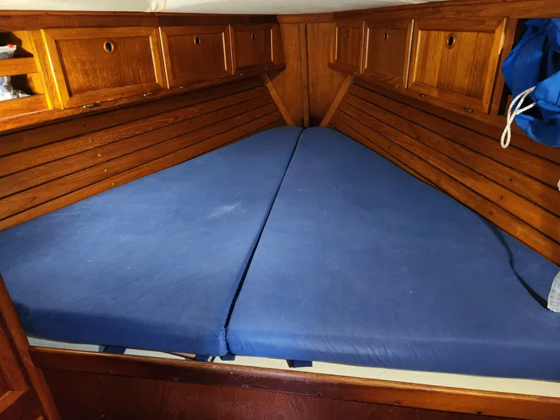 Slide: The Image of 1989 Granada 375 Atlantica boat cabin with blue mattress and wooden storage cabinets. - 8