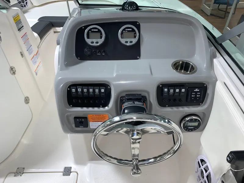 Slide: The Image of 2024 Robalo R207 Dual Console boat dashboard with steering wheel and control panel. - 10