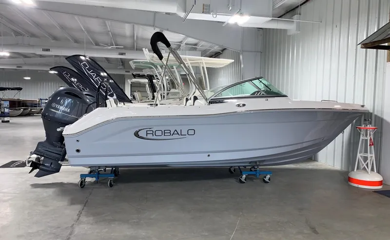 The Image of 2026 Robalo R207 Dual Console boat displayed indoors on stands. - 0