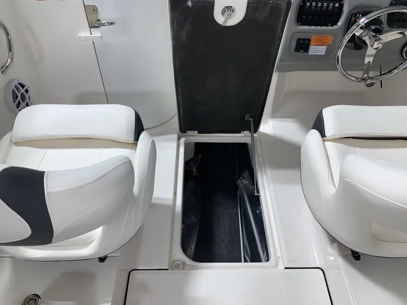 Slide: The Image of 2024 Robalo R207 Dual Console boat interior with white seating and storage compartment. - 11