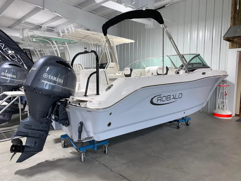 Slide: The Image of 2024 Robalo R207 Dual Console boat with Yamaha outboard motor in showroom. - 2