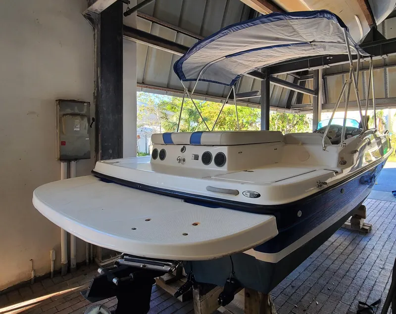 Slide: The Image of 2006 Bayliner 197 SD boat with blue and white exterior, stored indoors. - 3