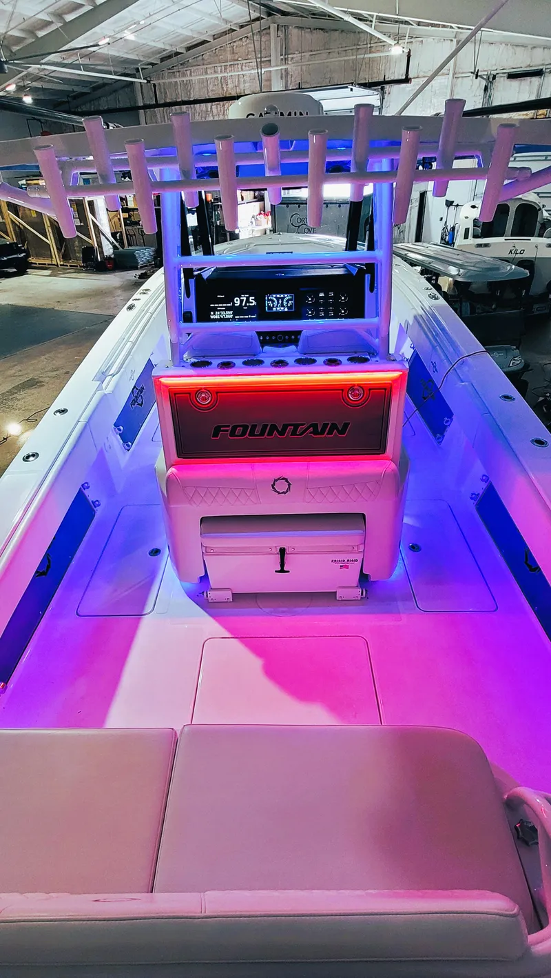 Slide: The Image of 2024 Fountain Bluewater 38 Tournament Edition boat with illuminated interior in a showroom. - 34