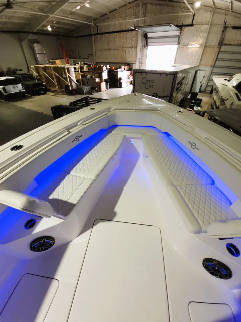 Slide: The Image of 2024 Fountain Bluewater 38 Tournament Edition boat with blue LED lighting in a warehouse. - 39