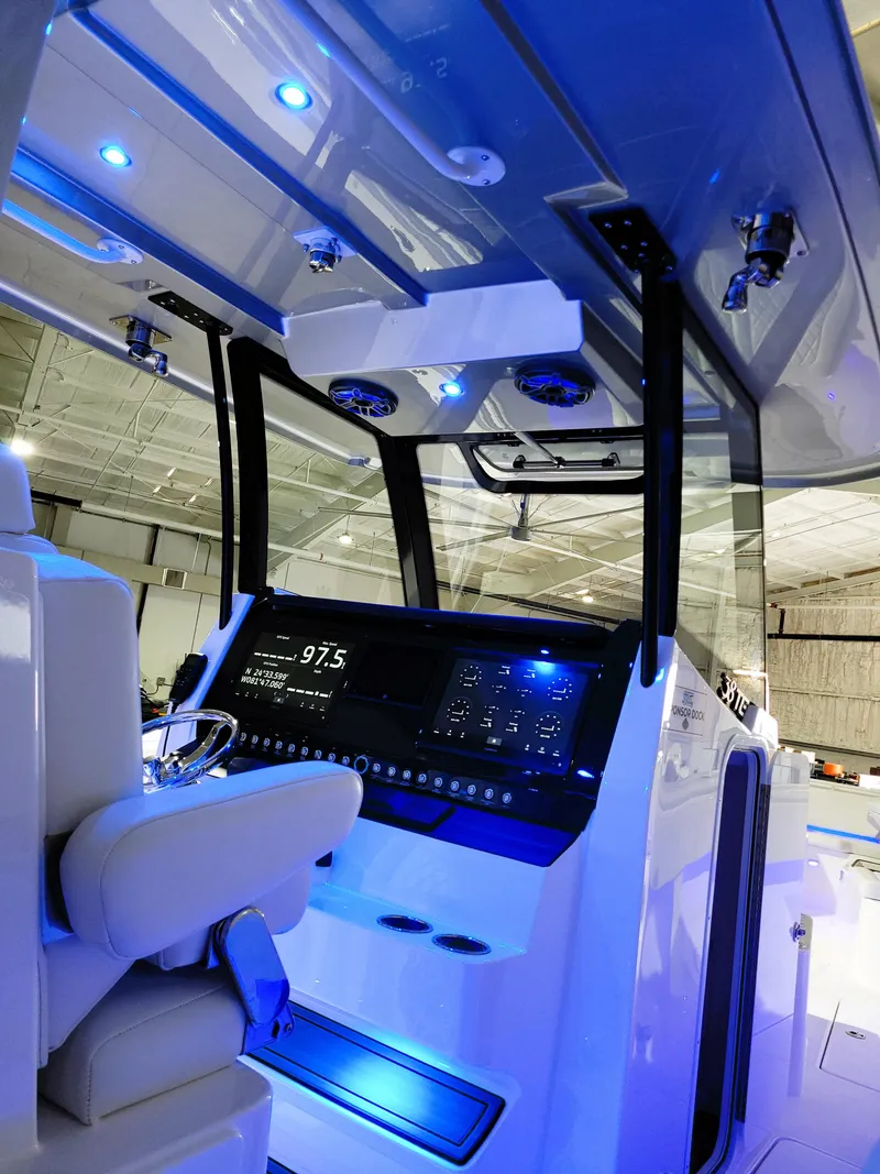 Slide: The Image of 2024 Fountain Bluewater 38 Tournament Edition boat interior with illuminated dashboard and seating. - 41