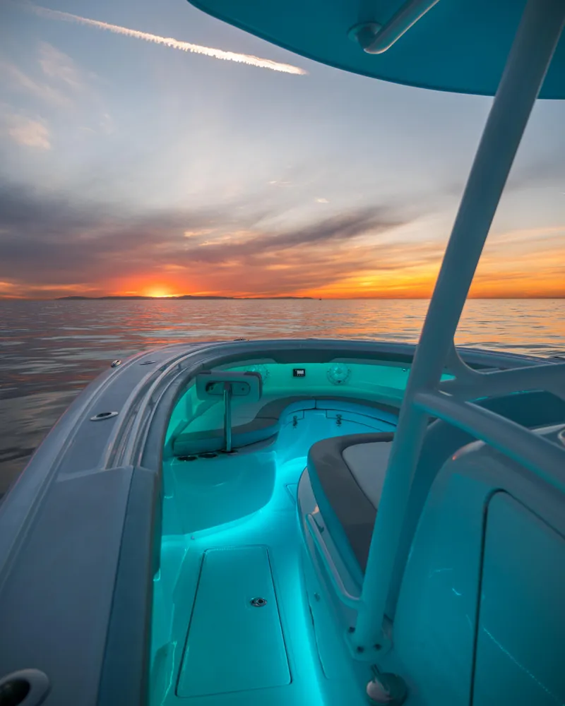 Slide: The Image of 2025 Mag Bay 33 CC boat at sunset with glowing interior lights. - 15