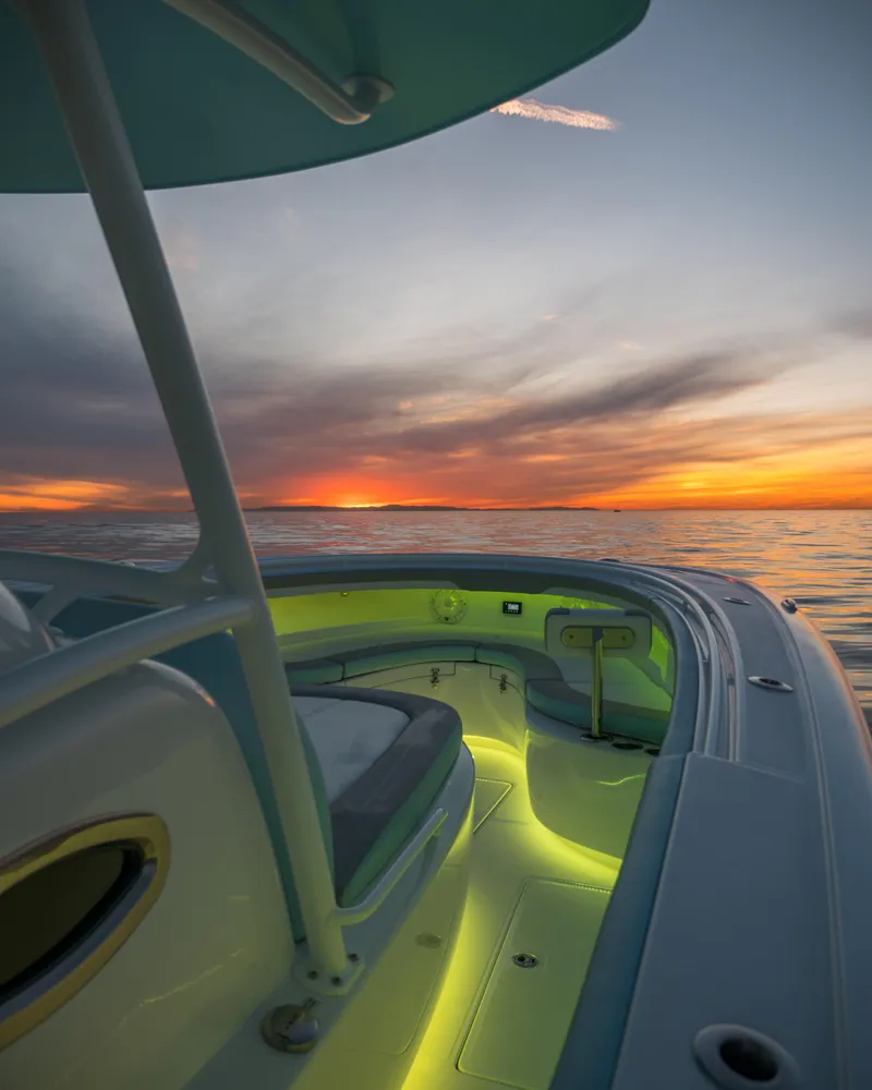 Slide: The Image of 2025 Mag Bay 33 CC boat at sunset with illuminated deck. - 19