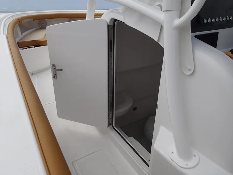 Slide: The Image of 2025 Mag Bay 33 CC boat interior with open door revealing a compact restroom. - 27