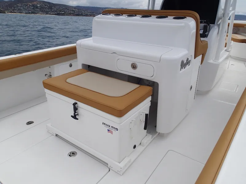 Slide: The Image of 2025 Mag Bay 33 CC boat interior with cushioned seating and cooler. - 28