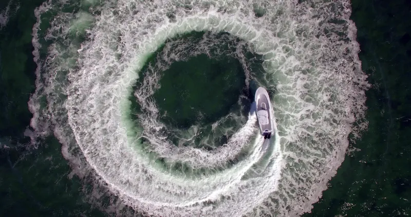 Slide: The Image of Aerial view of 2025 Mag Bay 33 CC boat creating circular wake patterns. - 30