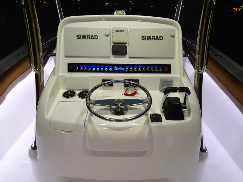 Slide: The Image of Mag Bay 33 CC 2025 boat console with Simrad electronics and illuminated controls. - 31