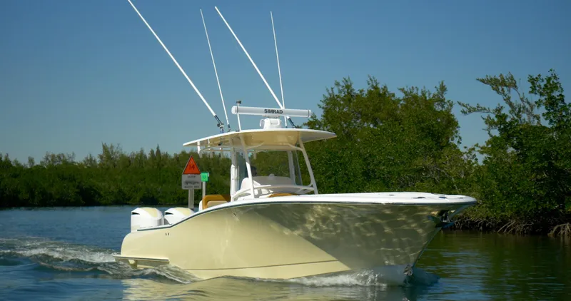 Slide: The Image of 2025 Mag Bay 33 CC boat cruising on a calm waterway. - 32