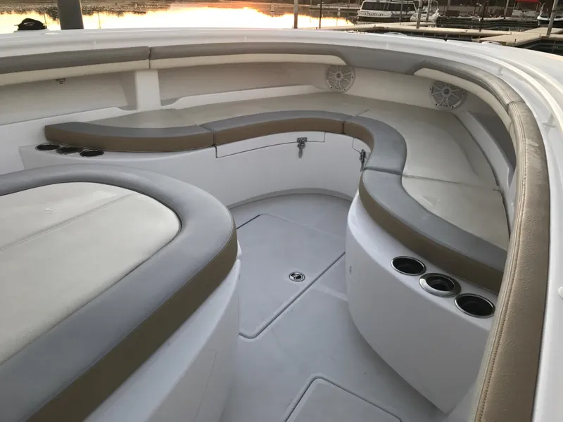Slide: The Image of 2025 Mag Bay 33 CC boat interior with cushioned seating and cup holders. - 33