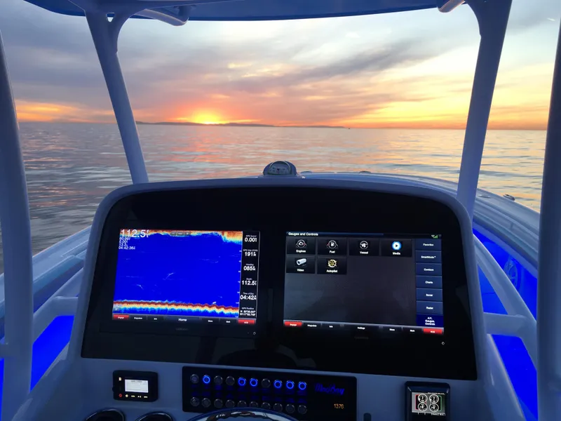 Slide: The Image of 2025 Mag Bay 33 CC boat dashboard at sunset on the water. - 42