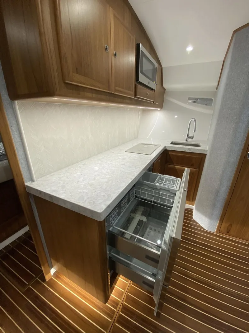 Slide: The Image of Modern kitchen area in 2025 Mag Bay 42 yacht with wooden cabinetry and stainless steel appliances. - 25