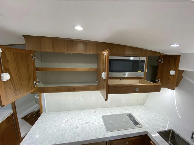 Slide: The Image of Mag Bay 42 2025 yacht kitchen with open cabinets, microwave, and modern countertop. - 26