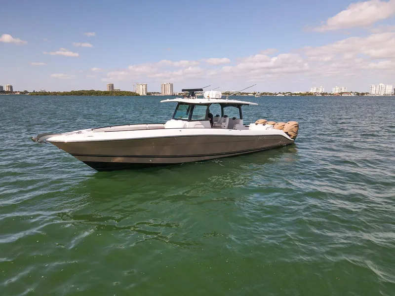The Image of A 2020 HCB 42 Siesta on calm water with a city skyline in the background. - 2