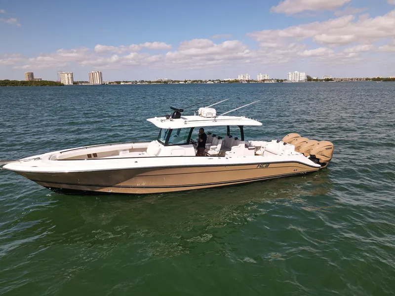 Slide: The Image of A 2020 HCB 42 Siesta on calm water with multiple outboard engines. - 0