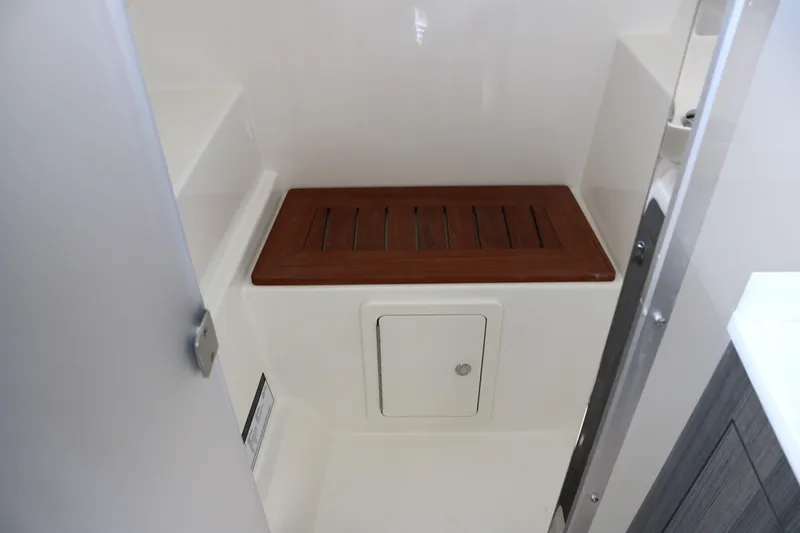 Slide: The Image of 2023 World Cat 400DC-X boat interior with wooden seat and storage compartment. - 15