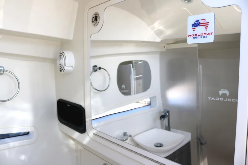 Slide: The Image of Interior of 2023 World Cat 400DC-X boat, featuring a modern bathroom with sink and mirror. - 16
