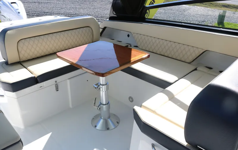 Slide: The Image of 2023 World Cat 400DC-X boat interior with cushioned seating and wooden table. - 24