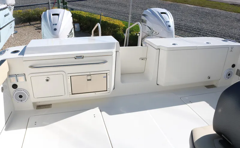 Slide: The Image of 2023 World Cat 400DC-X boat deck with storage compartments and twin outboard engines. - 28