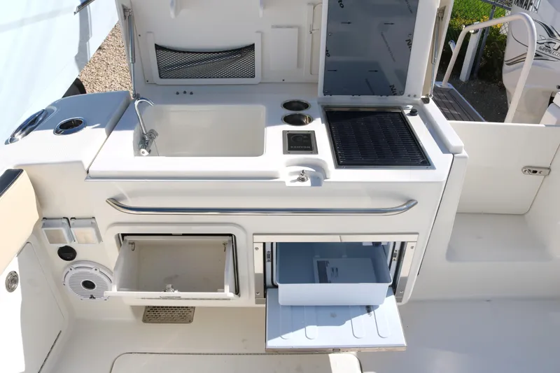 Slide: The Image of 2023 World Cat 400DC-X boat galley with sink, grill, and storage compartments. - 30