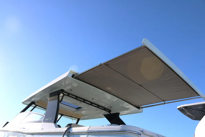 Slide: The Image of 2023 World Cat 400DC-X boat with extended sunshade under clear blue sky. - 4