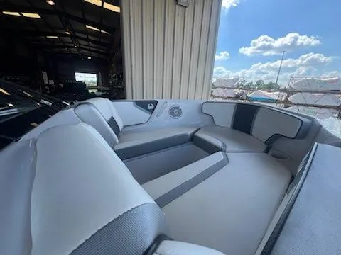 Slide: The Image of 2017 Scarab 195 boat interior with gray and black seating, docked in a warehouse. - 12