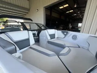 Slide: The Image of 2017 Scarab 195 boat interior with white and gray seating in a garage. - 13