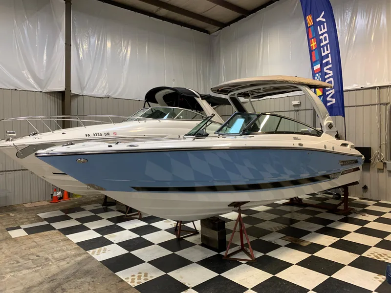 Slide: The Image of 2023 Monterey 298 Super Sport boat in showroom on checkered floor. - 0