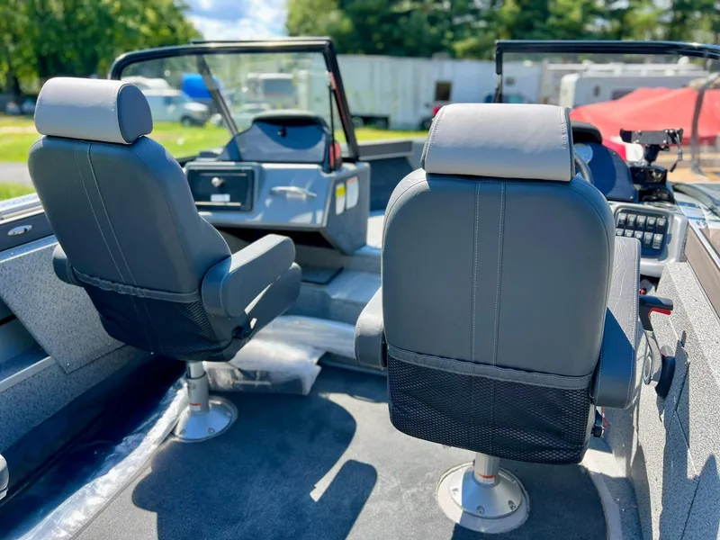 Slide: The Image of 2023 Starcraft Fishmaster 210 boat interior with two captain's chairs and dashboard. - 13