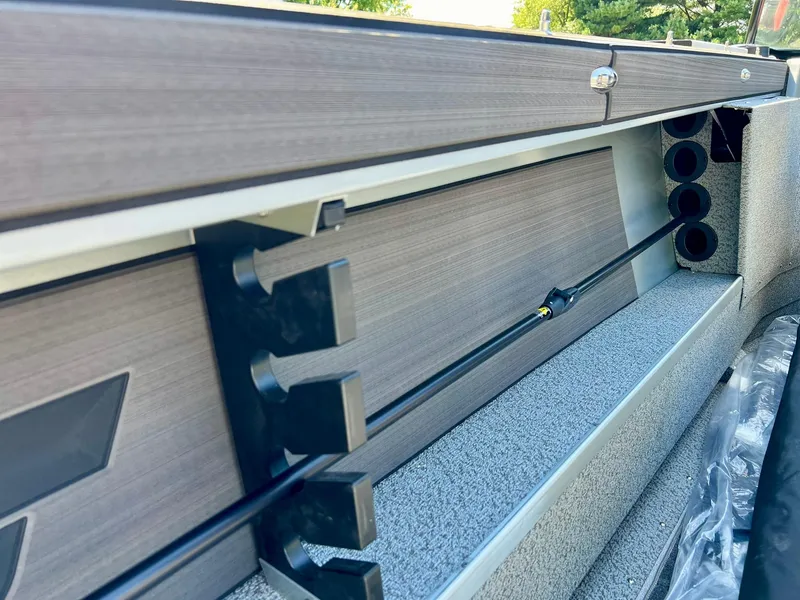 Slide: The Image of 2023 Starcraft Fishmaster 210 boat interior with rod holders and storage compartments. - 17