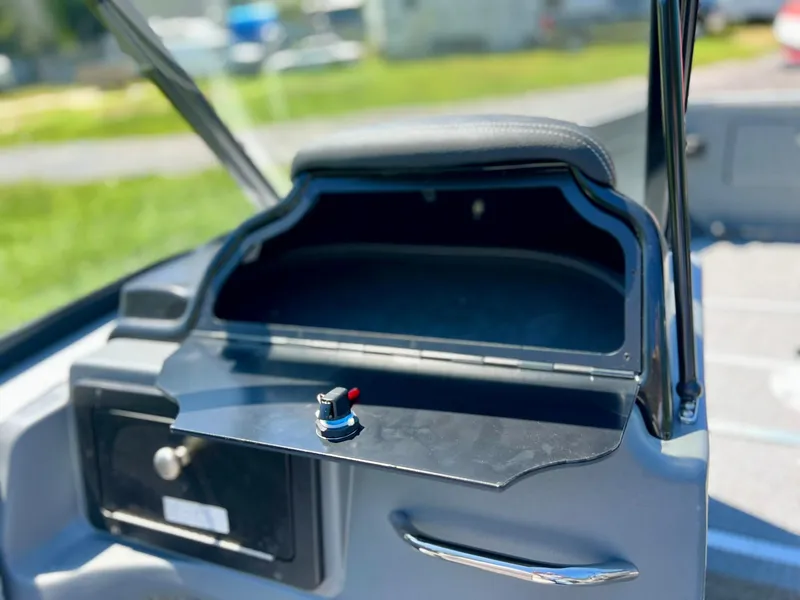 Slide: The Image of 2023 Starcraft Fishmaster 210 boat dashboard with open storage compartment. - 18