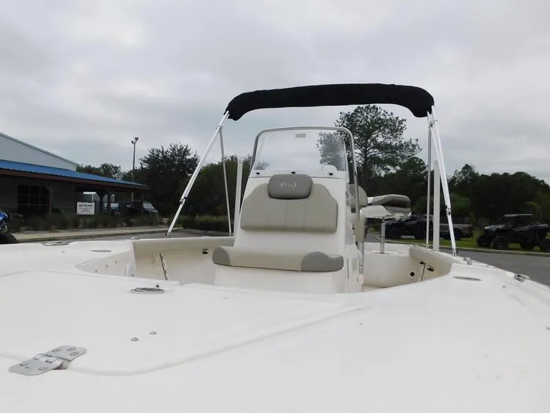 Slide: The Image of 2023 Key West 188 BR boat with bimini top and seating, docked outdoors. - 9