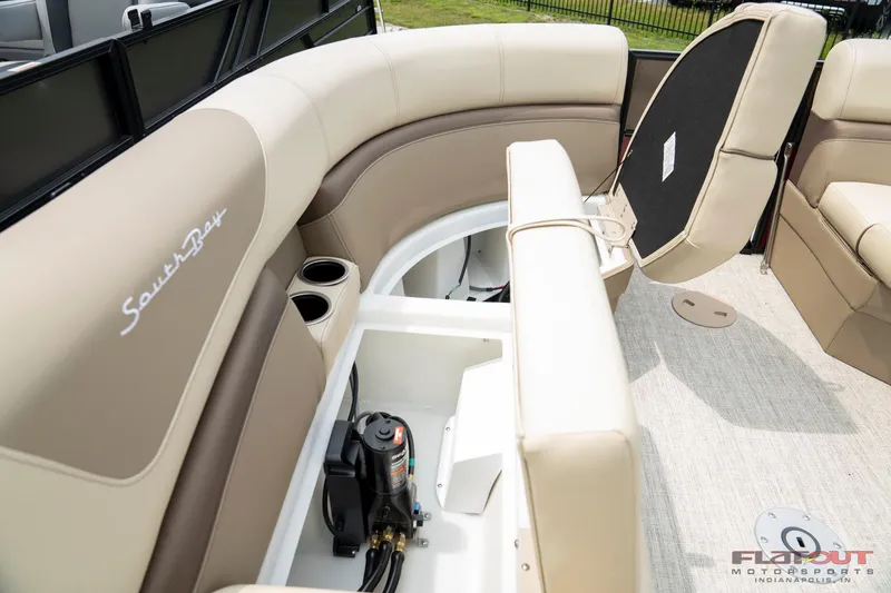 Slide: The Image of 2023 South Bay RearSeating 200hp boat interior with storage compartment and beige seating. - 5