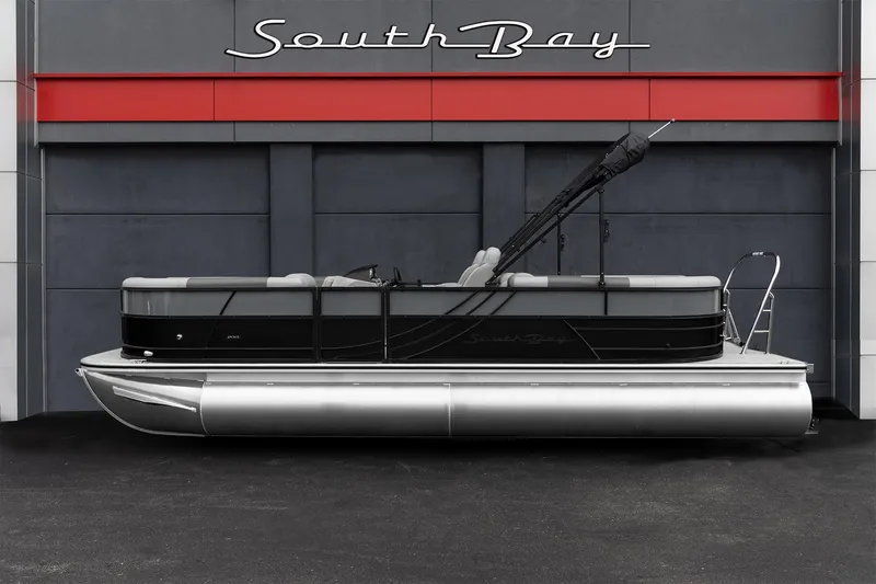 Slide: The Image of 2023 South Bay RearSeating 200hp pontoon boat in front of dealership. - 0