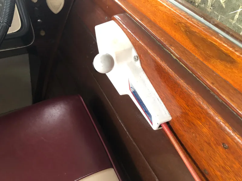 Slide: The Image of 1960 Chris-Craft 24 Sportsman interior, featuring wooden paneling and vintage control lever. - 15