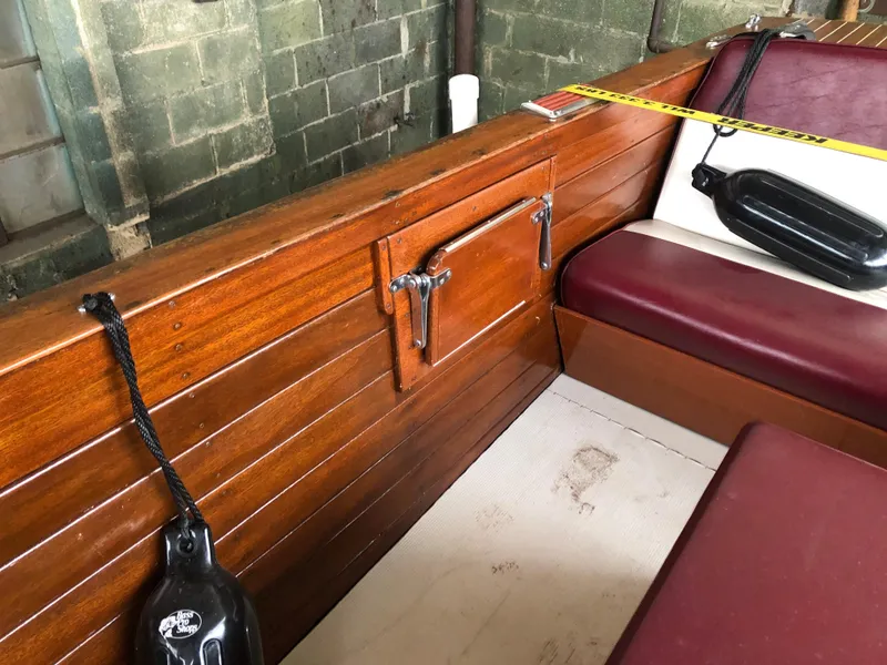 Slide: The Image of 1960 Chris-Craft 24 Sportsman interior with wooden paneling and maroon seating. - 16