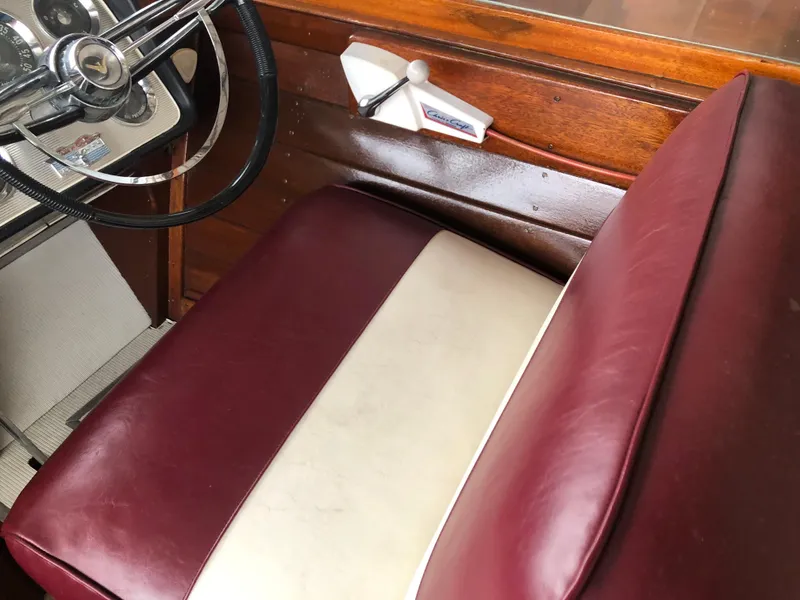 Slide: The Image of 1960 Chris-Craft 24 Sportsman interior with maroon and white leather seats and wooden dashboard. - 18