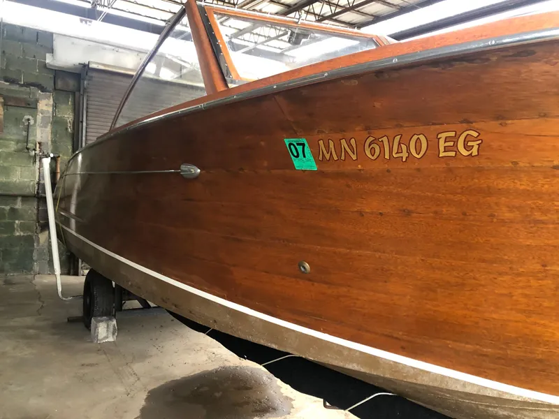Slide: The Image of 1960 Chris-Craft 24 Sportsman wooden boat in storage, side view with registration number. - 27
