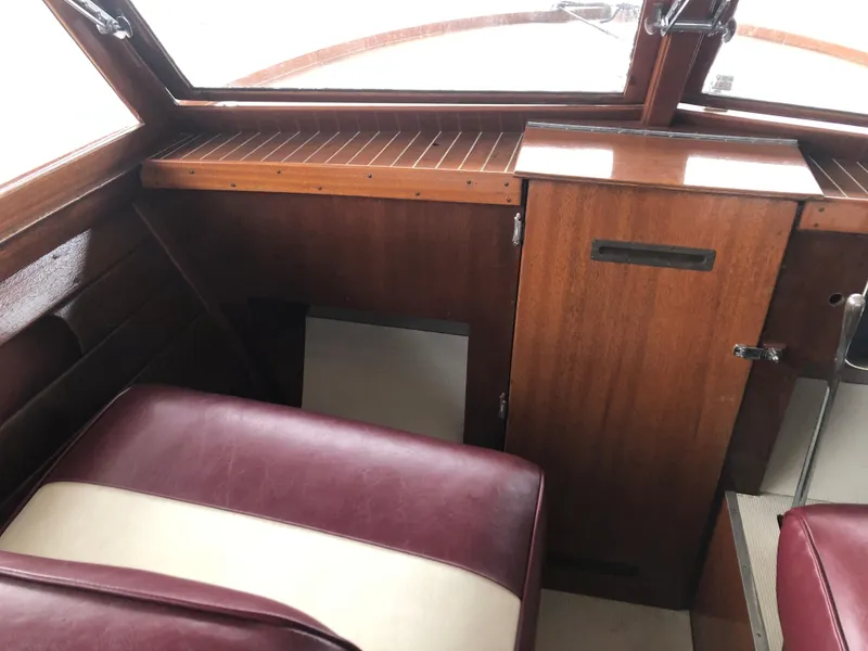 Slide: The Image of Interior of a 1960 Chris-Craft 24 Sportsman boat with wood paneling and maroon seats. - 6