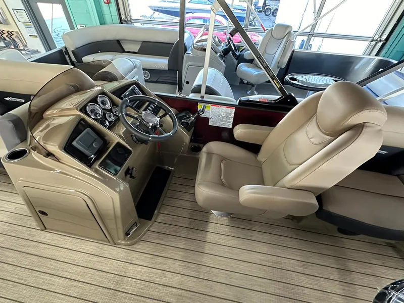 Slide: The Image of 2025 Sylvan Mirage X1 boat interior with beige seating and wood-style flooring. - 10