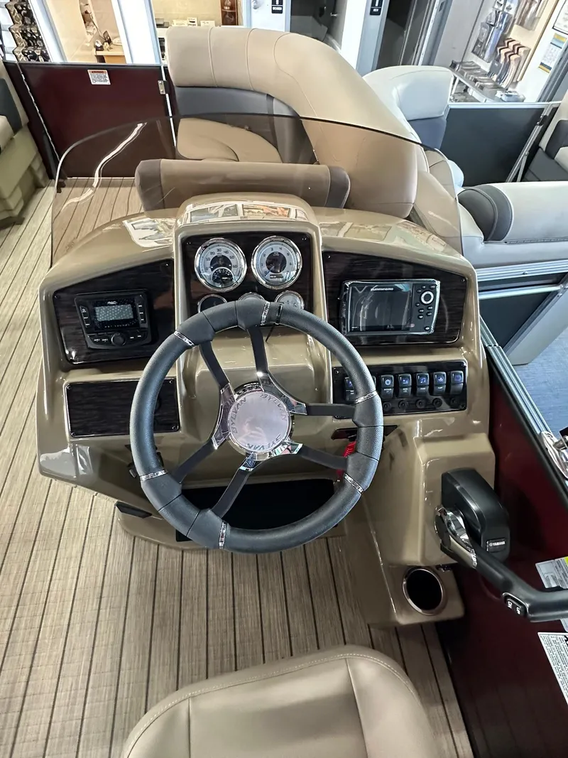 Slide: The Image of 2025 Sylvan Mirage X1 boat interior with beige seating and modern dashboard. - 11