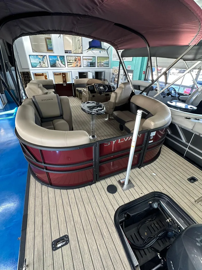 Slide: The Image of 2025 Sylvan Mirage X1 pontoon boat with 115 HP outboard motor in showroom. - 5